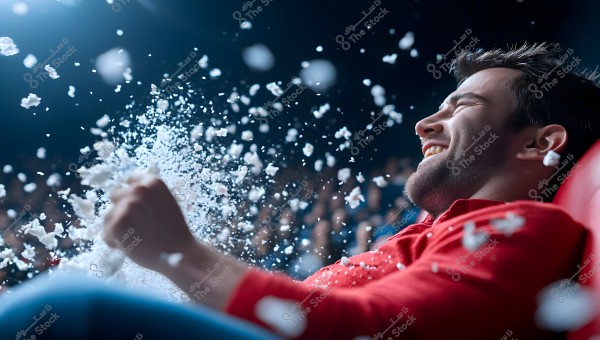 An image of a person sitting in a cinema, laughing as popcorn flies through the air around them. The person is wearing a red shirt and appears to be enjoying a movie. The background includes cinema seats and a crowd of seated people.
