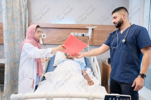 Saudi female doctor and paramedic in medical uniform and examining and applying nutritional solution, medicine and health care