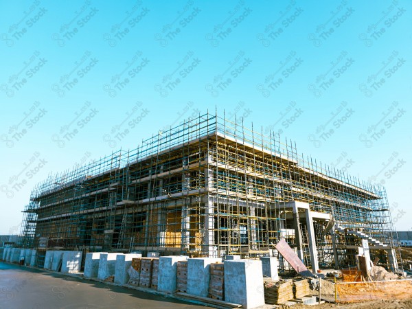 A construction site with a large building in the background. multi-storey building. A construction site with scaffolding and a large building in the background.