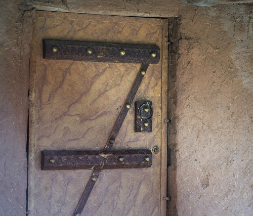 Wooden Antique door built into mud wall - Old traditional wooden door in Saudi Arabia