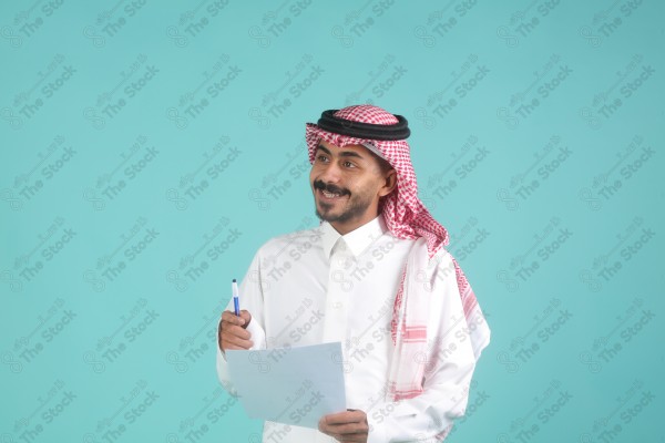 رجل سعودي يرتدي الزي السعودي يمسك بالاوراق،  يتحدث ويشرح فكرة العمل، اعمال مكتبية