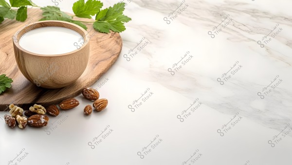 An image of a wooden cup containing milk or a white beverage, placed on a wooden board with almonds and walnuts on a marble surface. There are also some green mint leaves at the top side of the board.
