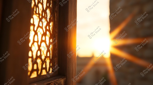 The image shows a wooden window with traditional Islamic patterns, where golden light from the setting sun filters through the geometric designs, casting shadows on the brown wooden frame. The sky in the background is glowing with a warm amber hue.