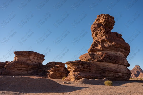 لقطة لسلسلة من الجبال الصخرية في وادي بتبوك بالسعودية وتبدوا السماء صافية نهارًا، تكوينات صخرية، الطبيعة بالسعودية