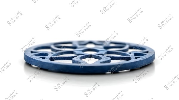 ** Close-up image of a circular blue disk with an intricate geometric openwork design. The disk is placed on a white surface, highlighting the details in the decorative pattern.\r\n\r\n**