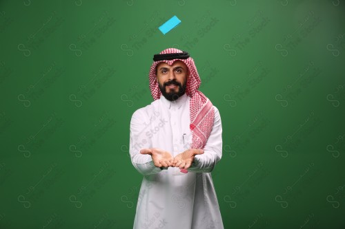 بورتريه رجل سعودي على خلفية خضراء متحمس يحمل بطاقة الصرافة مستعد للتسوق