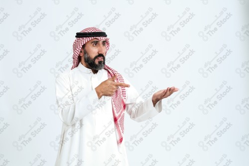 بورتريه رجل سعودي كبير بالسن يرتدي الزي الرسمي التقليدي على خلفية بيضاء يقوم بعمل اشارات بيديه وهو مبتسم ، حزين، غاضب، صور تذكارية ، توثيق لحظة سعيدة.