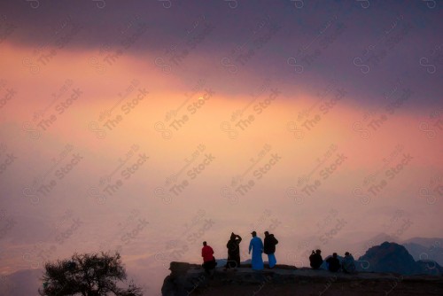 A snapshot of the rocky mountains in the city of Taif, and the sky appears cloudy in western Saudi Arabia, a group of people on top of the mountain.