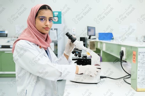 Saudi doctor in a hospital works in a laboratory, a medical team uses a microscope to examine a blood sample, and works in the field of health, providing medical consultations and medical health services.