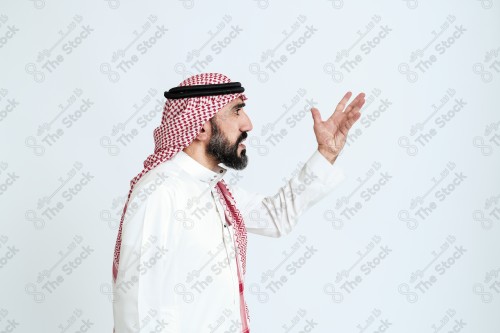 بورتريه رجل سعودي كبير بالسن يرتدي الزي الرسمي التقليدي على خلفية بيضاء يقوم بعمل اشارات بيديه وهو مبتسم ، حزين، غاضب، صور تذكارية ، توثيق لحظة سعيدة.