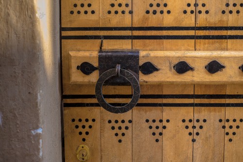 Wooden Antique door built into mud wall - Old traditional wooden door in Saudi Arabia