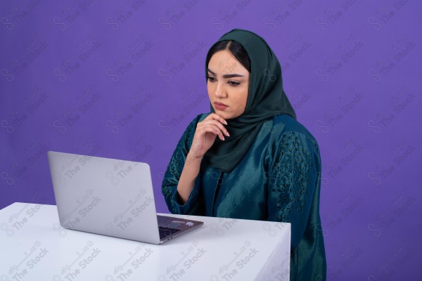 Portrait of a young Saudi woman wearing an abaya and hijab, holding a pen and thinking, against a purple background