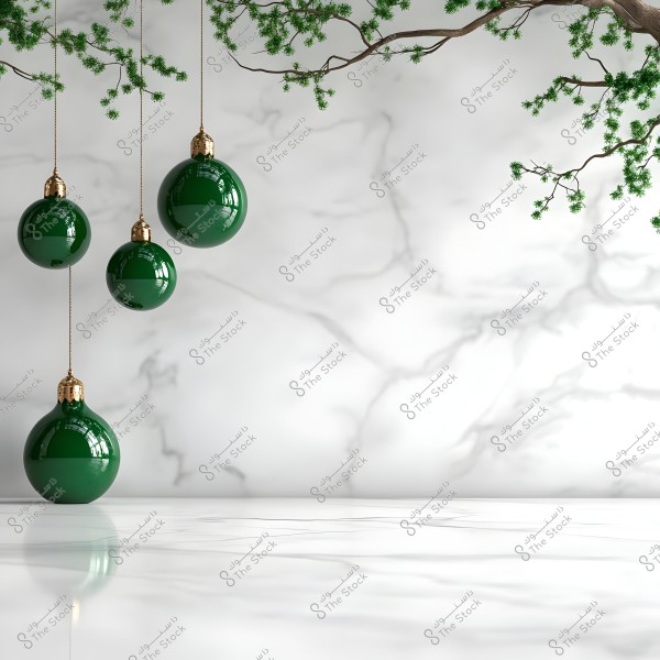 The image shows four green ornament balls hanging from tree branches against a white marble background. The branches have small green leaves, adding a festive and minimalist touch to the scene. The floor is also marble, reflecting light attractively.