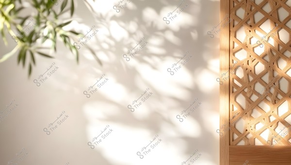 Image showing the shadow of tree leaves extending over a white wall, with a geometric wooden design on the right side of the image. The shadows and patterns create a sense of calm and warmth.
