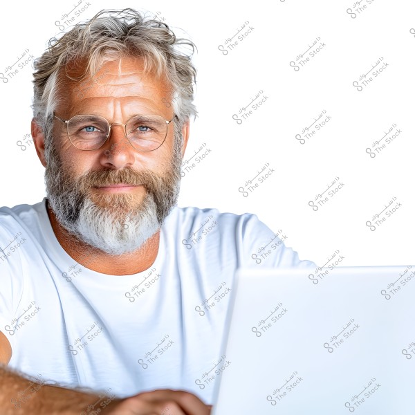 صورة لرجل ذو شعر أبيض ولحية يرتدي نظارات وقميصًا أبيض, جالسًا أمام كمبيوتر محمول. يبدو أن الخلفية بيضاء وبيئة الصورة حديثة.