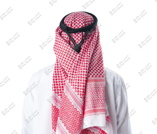 An image showing a person wearing a traditional white thobe with a red and white checkered shemagh covering the head, secured with a black agal. This attire is traditional in countries like Saudi Arabia.