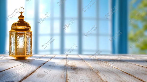 A decorative golden lantern with a traditional design sits on a light wooden surface, under daylight. In the background, there is a large window with a slight blurry effect and greenery outside.