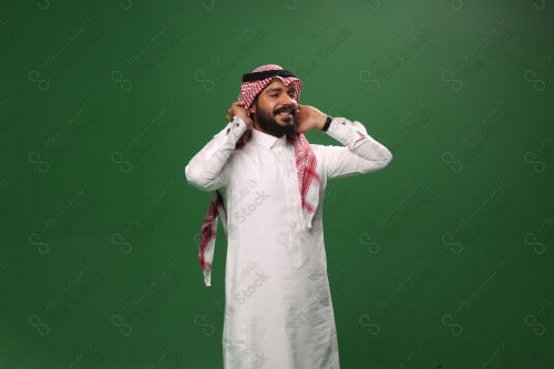 بورتريه رجل سعودي يرتدي الزي السعودي التقليدي يُصلح هندامه