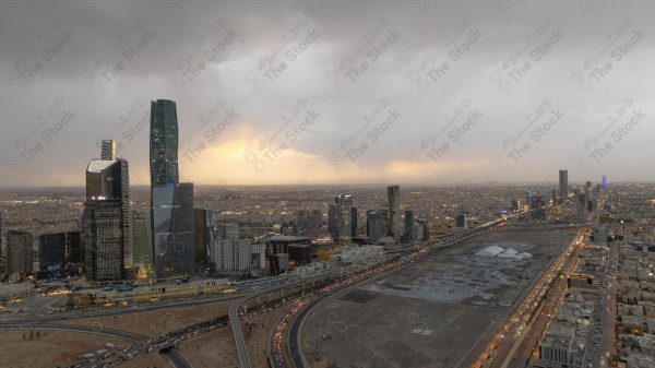 لقطة جوية للأبراج مركز الملك عبدالله المالي في العاصمة الرياض وتظهر السماء غائمة اثناء الغروب، حركة المرور في مدينة الرياض