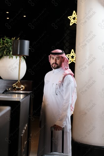 شاب سعودي في استقبال الفندق ، وتظهر حقيبة السفر