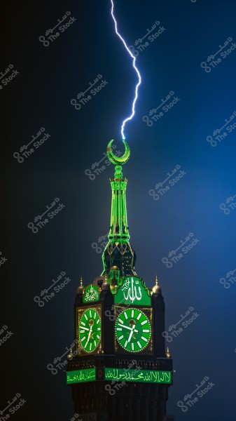 صاعقة تضرب ساعة مكة الملكية مضيئة باللون الأخضر ليلاً في مكة المكرمة, المملكة العربية السعودية.
