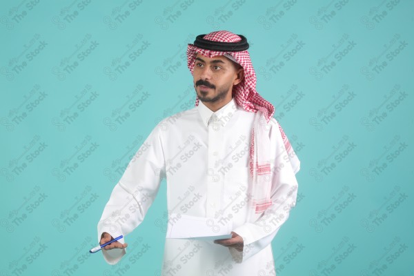 رجل سعودي يرتدي الزي السعودي يمسك بالاوراق،  يتحدث ويشرح فكرة العمل، اعمال مكتبية