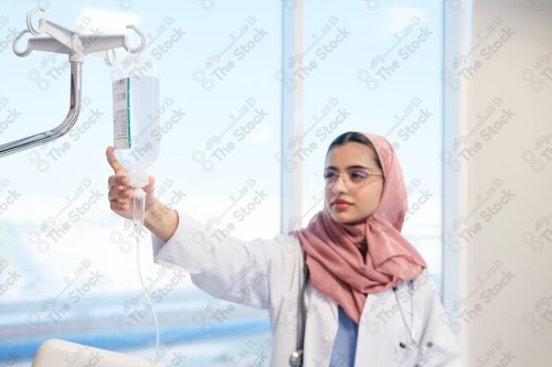 A Saudi female doctor wears a medical uniform and is examining and applying a nutrient solution, medicine and health care