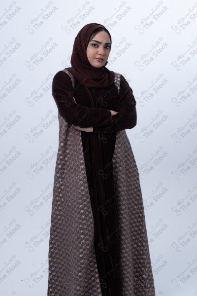 A young Saudi woman wearing an abaya and hijab, looking angry