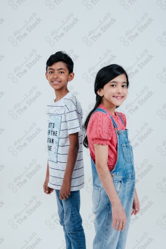 A boy and a girl standing proud and confident on a white background, different facial expressions and hands.