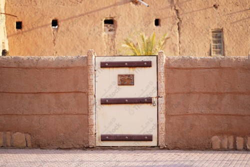 Wooden Antique door built into mud wall - Old traditional wooden door in Saudi Arabia