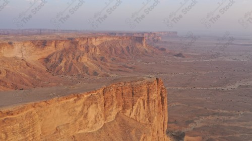 لقطة جوية لمجموعة سياح على جبل من جبال طويق المسمى بحافة العالم. سلسلة من الجبال الصخرية