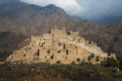 An overhead shot of a series of rocky mountains, in the middle of which is the ancient village of Dhi Ain in Al-Baha, archaeological tourist attractions.