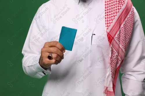 رجل سعودي على خلفية خضراء يحمل ببطاقة الصرافة مستعد للتسوق