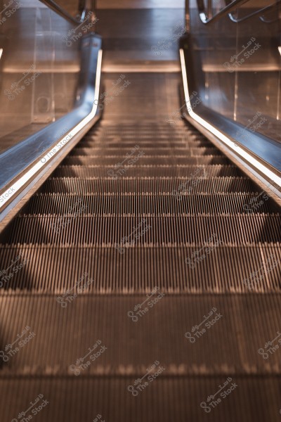 سلم كهربائي يظهر من الأعلى إلى الأسفل مع إضاءة جانبية.