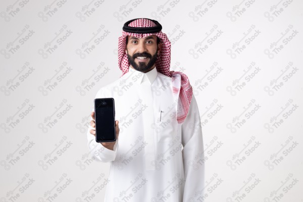 Portrait of a Saudi man holding an automatic payment device and making different expressions