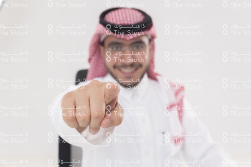 شاب سعودي يشير الى الكاميرا