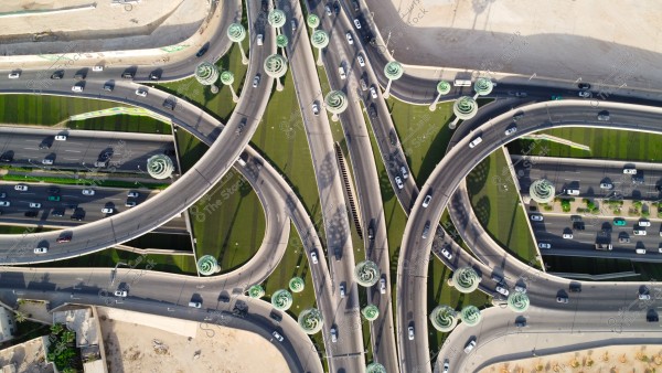 تصوير جوي لحركة سير السيارات على الطريق السريع في مدينة الرياض، الفن الهندسي المعماري للمجسمات الفنية على شكل أشجار خضراء، الطرق المتقاطعة في دوار عرقة بالمملكة العربية السعودية، البنية التحتية المتطورة
