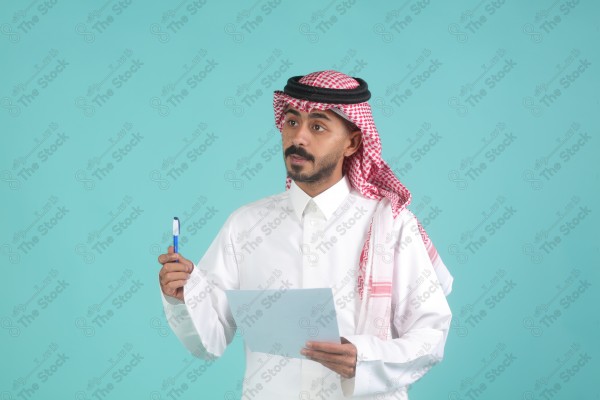 رجل سعودي يرتدي الزي السعودي يمسك بالاوراق،  يتحدث ويشرح فكرة العمل، اعمال مكتبية