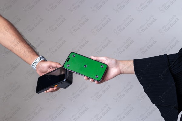 Portrait of a Saudi woman holding a card and making automatic payments on a white background