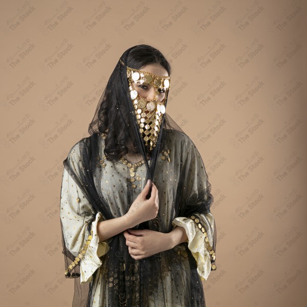 Saudi woman wearing a Saudi Najdi costume representing folklore on a brown background, foundation day