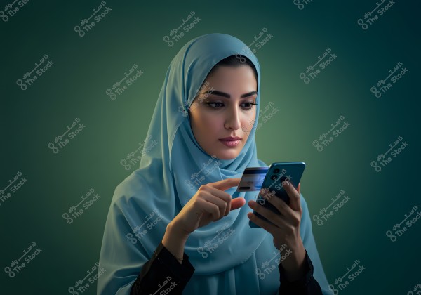 Image of a woman wearing a blue hijab, suggesting an Arab origin. The woman appears focused while using a smartphone and holding a credit card, indicating an online shopping or e-commerce activity. The background is a dark green, highlighting the calm and composed feel of the image.