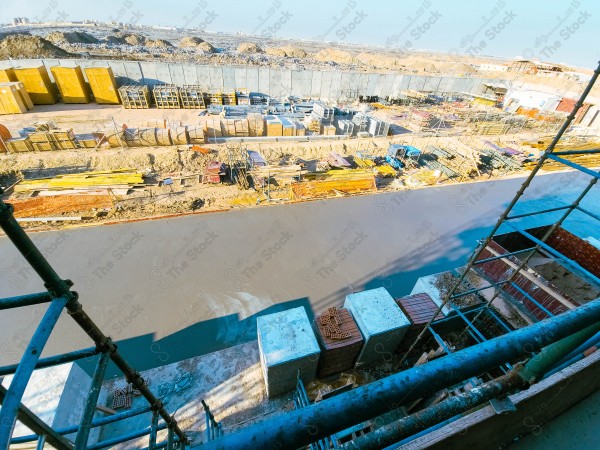 A construction site with a large building in the background. multi-storey building. A construction site with scaffolding and a large building in the background.