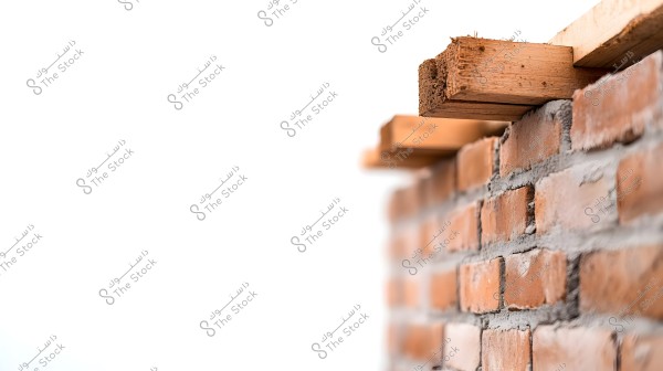A close-up image of a red brick wall with wooden beams placed on top. The bricks are neatly stacked with visible mortar between the layers. The wooden beams are clearly shown with rough edges at the top of the image.
