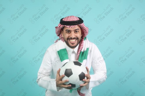 شاب سعودي يرتدي الزي السعودي، ممسك بيده كره القدم ، كأس العالم