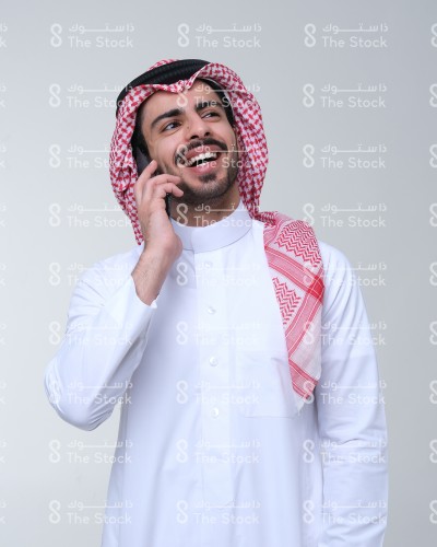 رجل سعودي يحمل هاتفه النقال