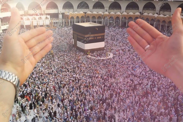 صورة للكعبة المشرفة وسط حشود من الحجاج في المسجد الحرام, ويدان مرفوعتان بالدعاء في المقدمة.