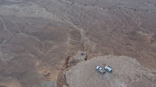 لقطة جوية لمجموعة سياح على جبل من جبال طويق المسمى بحافة العالم. سلسلة من الجبال الصخرية