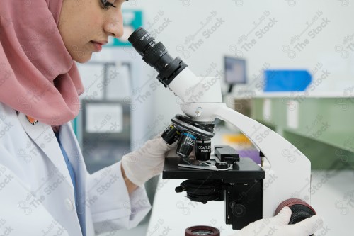 Saudi doctor in a hospital, working in a laboratory that analyzes a sample on a microscope, working in the health sector, providing medical consultations and health services, medicine and health care