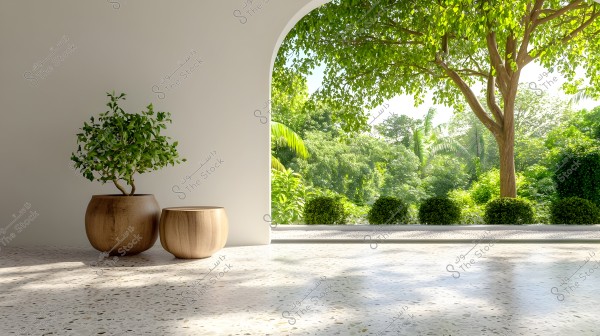 An interior corner view of a room with white-painted walls and a shiny marble floor. On the floor, there are two wooden pots, the larger containing a lush green shrub. Through an arch in the wall, a vibrant outdoor view of a green garden is visible, featuring a large tree and various shrubs and trees in the background, as natural light streams in through the arch.