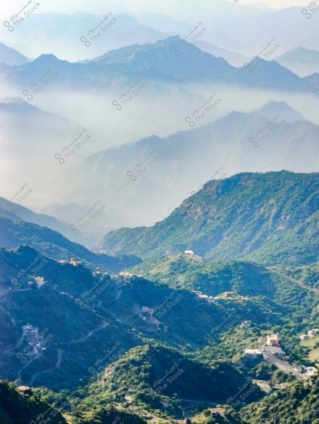 A stunning landscape of successive mountain ranges covered in green vegetation, extending into a misty horizon. Small farms and homes are scattered among the mountains, surrounded by winding roads.
